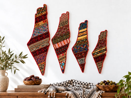 Four Palestine map tatreez wall hangings in different sizes on a wall